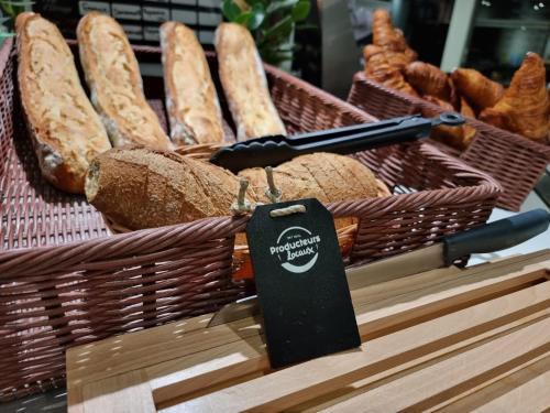 a bunch of baskets of bread on a table at Brit Hotel La Bonne Etape in Évreux