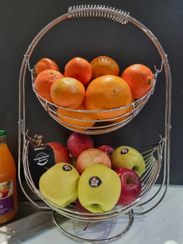un panier de fruits sur une table avec des pommes et des poires dans l'établissement Brit Hotel La Bonne Etape, à Évreux