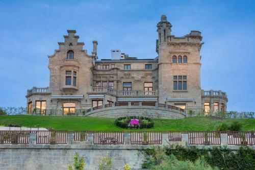 an old castle with a fence in front of it at Palacio Arriluce Hotel in Getxo