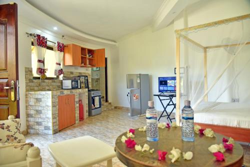 ein Zimmer mit einer Küche und einem Wohnzimmer mit einem Tisch in der Unterkunft Wembley Villa Diani Beach in Diani Beach