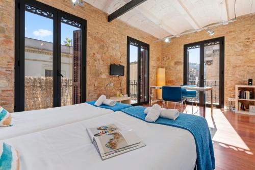 a bedroom with a large bed and large windows at AB Paral-lel Tapioles in Barcelona