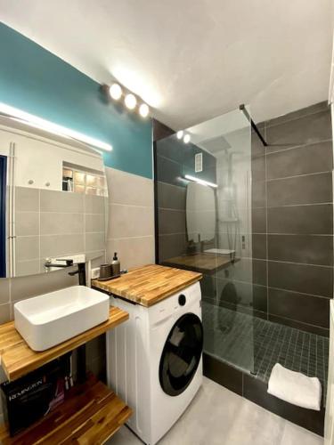 une salle de bain avec une machine à laver et un lavabo dans l'établissement T4 proche centre ville: 6 pers - balcon - clim, à Avignon
