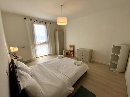 une chambre blanche avec un grand lit et une fenêtre dans l'établissement T4 proche centre ville: 6 pers - balcon - clim, à Avignon