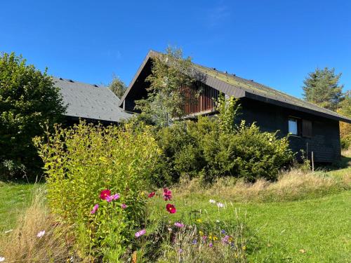 an old house with flowers in front of it at Holiday Home Rechbergblick - BEU302 by Interhome in Bernau im Schwarzwald