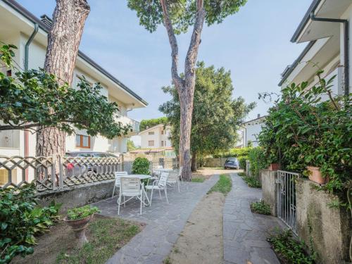 a courtyard with a table and chairs and trees at Apartment Dei Fiori by Interhome in Lido di Camaiore