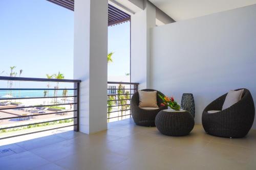 a room with two chairs and a balcony with the ocean at Kandaya Resort in Daanbantayan
