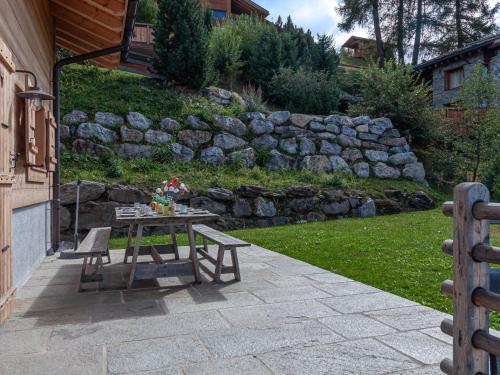 a patio with a table and benches in a yard at Chalet Chalet Jadi by Interhome in Nendaz
