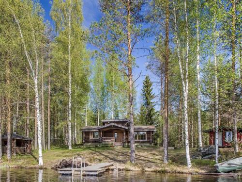 une cabane en rondins dans les bois à côté d'un lac dans l'établissement Holiday Home Papanmökki by Interhome, à Huuhanaho