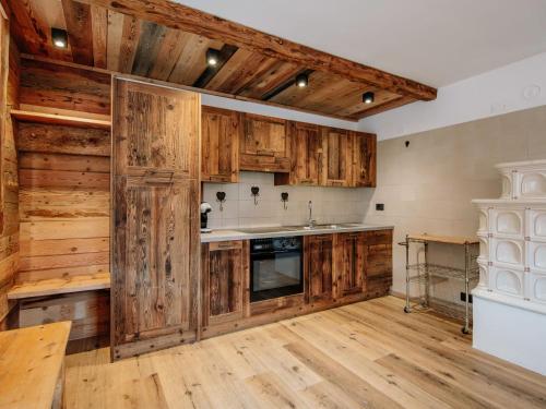 una cucina con armadi in legno e pavimenti in legno di Apartment Storie di Montagna by Interhome a Campestrin