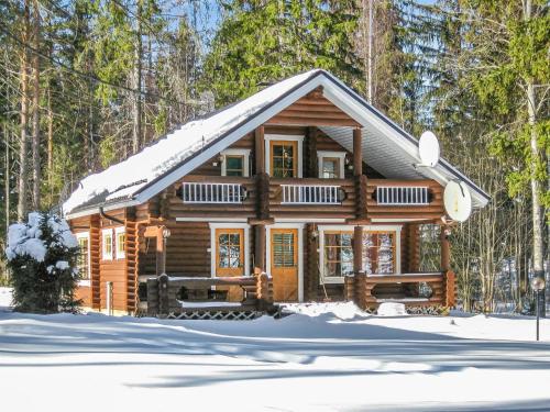 una baita di tronchi nel bosco nella neve di Holiday Home Purnuranta c by Interhome a Kolinkylä