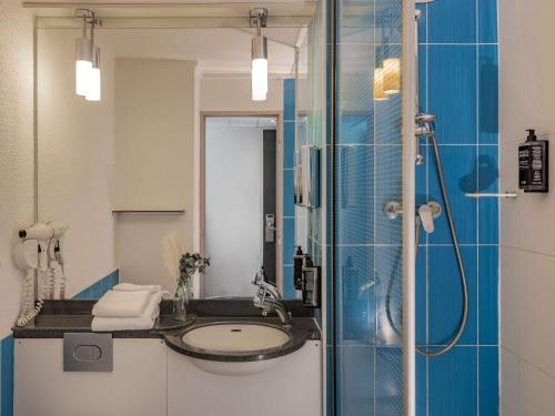 uma casa de banho com um lavatório e um chuveiro em ibis Styles Fontenay em Fontenay-sous-Bois