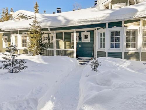 una casa con un montón de nieve delante de ella en Holiday Home Rukan taikavuosselin helmi 8 b by Interhome, en Ruka
