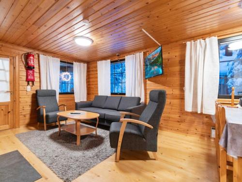 a living room with a couch and chairs and a table at Holiday Home Kaltiotievantie 2 mökki 2 by Interhome in Ylläsjärvi