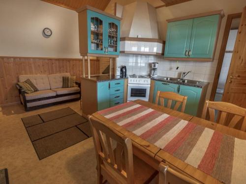 una cucina con armadi blu e un tavolo in una stanza di Holiday Home Satulinna by Interhome a Matildedal