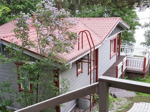 a small house with a pink roof and a porch at Holiday Home Lomaranta by Interhome in Paksalo