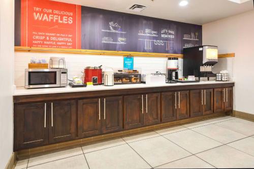a kitchen with a counter with a microwave and appliances at Hampton Inn Bryant in Bryant