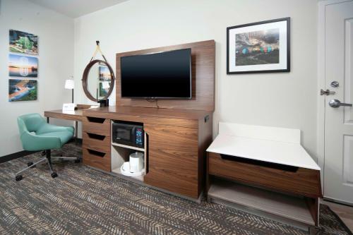 a room with a tv and a desk and a chair at Hampton Inn Bryant in Bryant