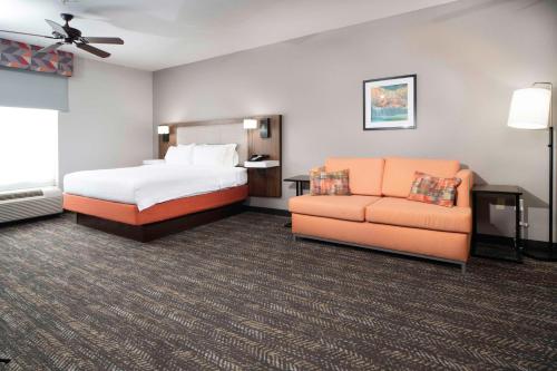 a hotel room with a bed and a couch at Hampton Inn Bryant in Bryant