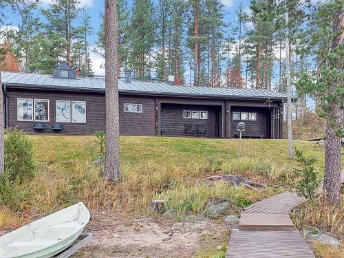 ein Blockhaus mit einem Boot davor in der Unterkunft Holiday Home Petäjälahti by Interhome in Petäjävesi