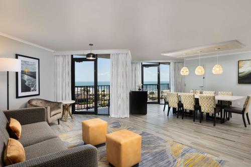 a living room with a table and a dining room at Hilton Galveston Island Resort in Galveston