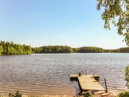 een dok op een meer met bomen op de achtergrond bij Holiday Home Villa hermanni by Interhome in Jäppilä