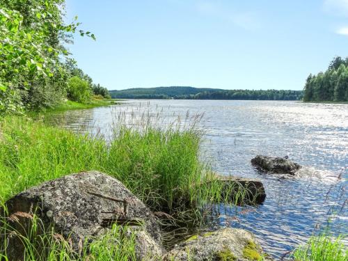 een uitzicht op een rivier met rotsen en gras bij Holiday Home Käpälysmökki by Interhome in Nurmes