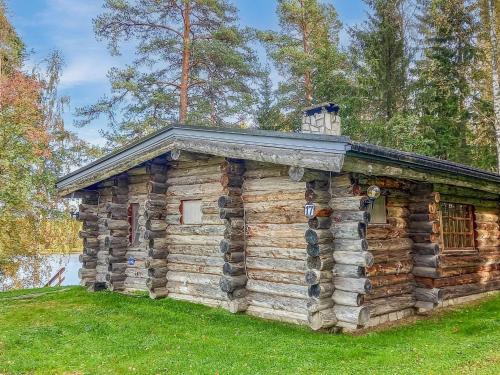 una baita di tronchi con un tetto di stagno sull'erba di Holiday Home Kelosyväri 17 by Interhome a Nilsiä