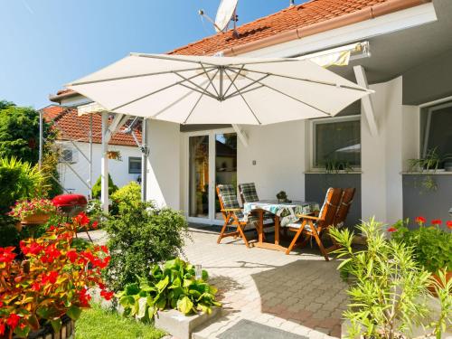 un patio con mesa, sillas y sombrilla en Holiday Home Ildiko by Interhome, en Balatonlelle