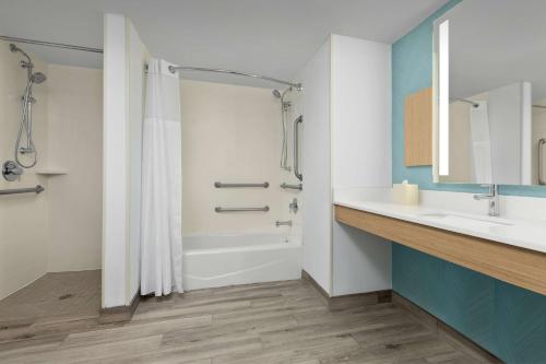 a bathroom with a sink and a tub and a shower at Hilton Garden Inn Greensboro in Greensboro