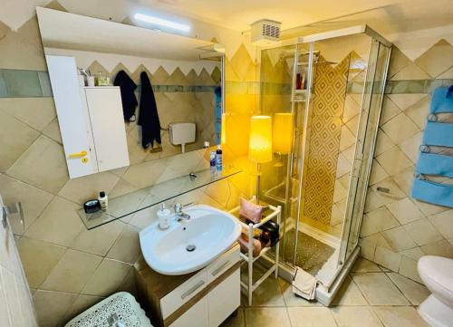 une salle de bain avec un lavabo et une douche dans l'établissement Villino con vista mare e piscina, à Palau