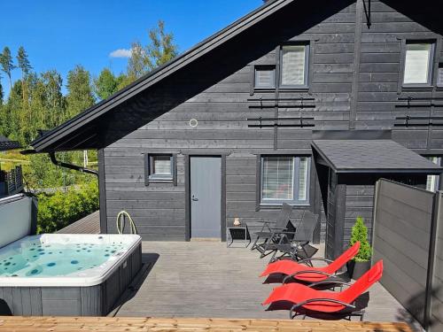 a deck with chairs and a pool and a house at Holiday Home Himoksen keiju 1 by Interhome in Jämsä