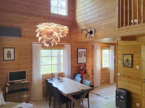 una sala da pranzo con tavolo e lampadario pendente di Holiday Home Villa hanhi by Interhome a Rovaniemi