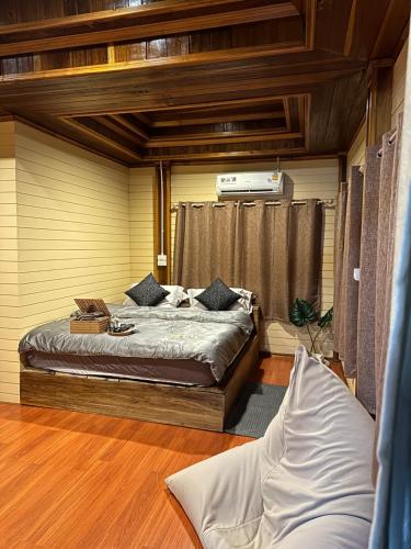 ein Schlafzimmer mit einem Bett in einem Zimmer in der Unterkunft Hi Land Forest View in Amphoe Chiang Dao