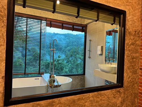 ein Badezimmer mit zwei Waschbecken, einer Badewanne und einem Fenster in der Unterkunft Hi Land Forest View in Amphoe Chiang Dao