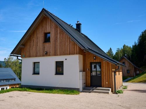 a large wooden house with a garage at Holiday Home Muhu by Interhome in Smržovka