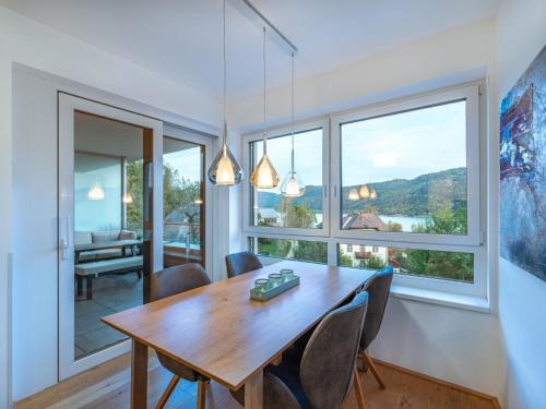 een eetkamer met een tafel en stoelen en een groot raam bij Apartment Seeblick alpe maritima Ski & See-Top 12 by Interhome in Annenheim