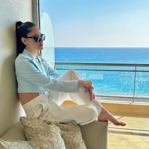 a woman sitting on a chair in front of a window at Mediterranean Hotel in Rhodes Town