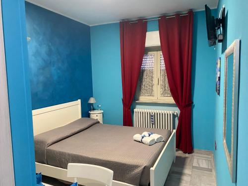 Schlafzimmer mit einem Bett mit blauen Wänden und roten Vorhängen in der Unterkunft Residenza Manfredi in Potenza