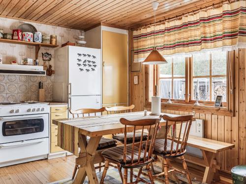 a kitchen with a wooden table and chairs and a stove at Chalet Norrskensstugan - NBO010 by Interhome in Vidsel