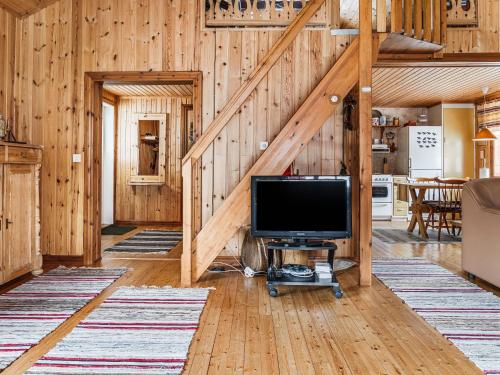 a living room with a television and a staircase at Chalet Norrskensstugan by Interhome in Vidsel