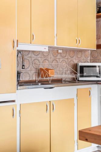 a kitchen counter with a sink and a microwave at Chalet Norrskensstugan by Interhome in Vidsel