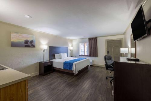 a hotel room with a bed and a desk at Travelodge by Wyndham Livingston in Livingston