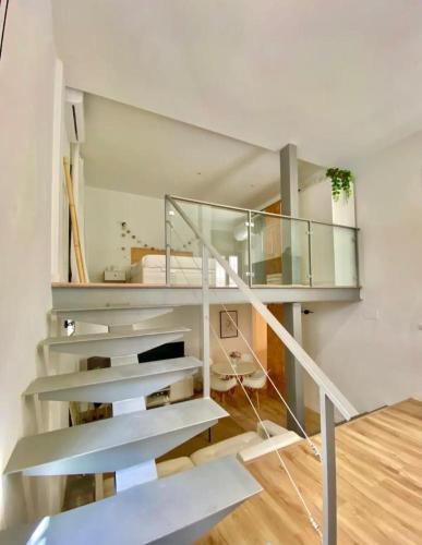 un escalier dans une maison avec rampe en verre dans l'établissement Loft Alameda en Sevilla, à Séville