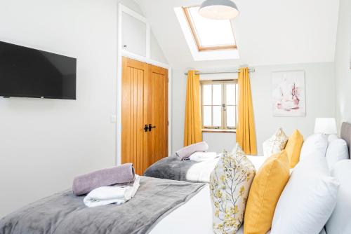 1 Schlafzimmer mit 2 Betten und einem TV an der Wand in der Unterkunft Cosy House Free Driveway Parking Good Location in New Bilton