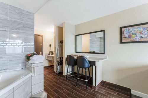 麥迪遜的住宿－麥迪遜伊克諾旅店，带浴缸和盥洗盆的浴室以及书桌。