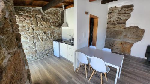 cocina y comedor con mesa y sillas en Quinta Vilar de Lobos, en Arcos de Valdevez