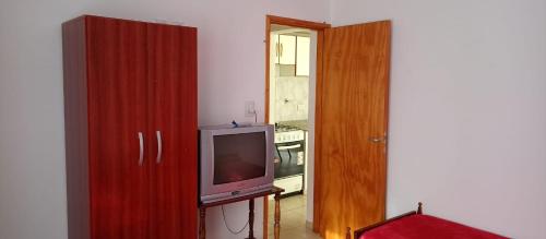 uma sala de estar com uma televisão e um armário de madeira em Alquiler x día Bolívar em San Carlos de Bolívar