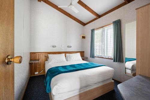 a bedroom with a large bed and a window at Bright Accommodation Park in Bright