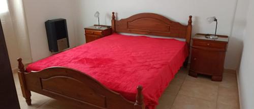 um quarto com uma cama vermelha e duas mesas de cabeceira em Alquiler x día Bolívar em San Carlos de Bolívar