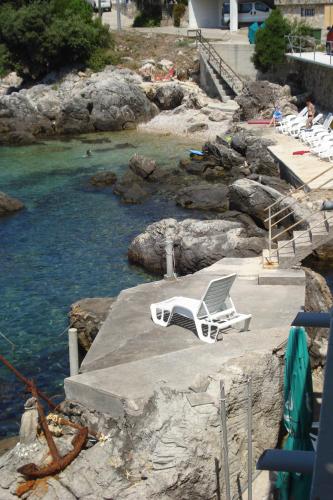 a white chair sitting on a dock next to the water at "Azzurra Apartments in Molunat